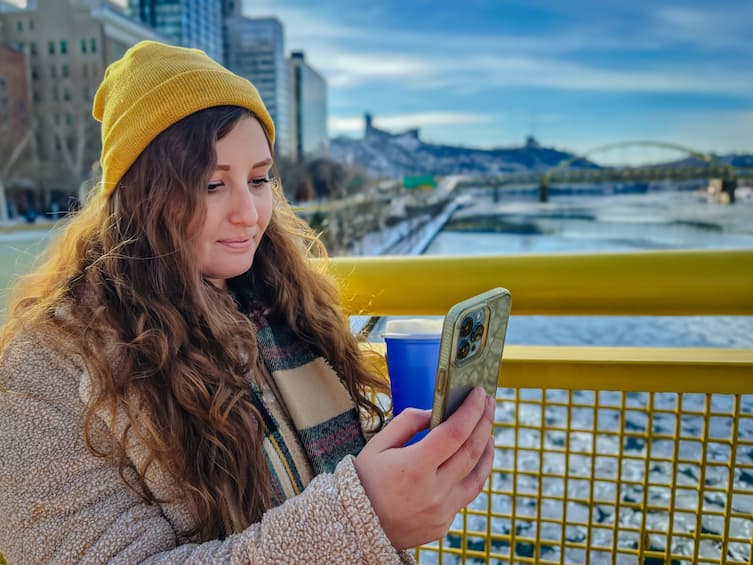 Woman looking at her mobile phone on a bridge