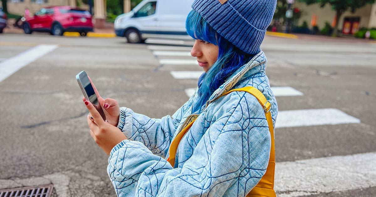 student on phone with bag