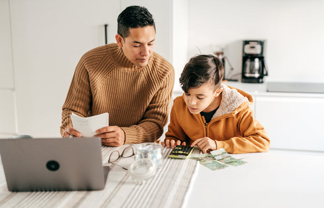Father and son calculating on a calculator