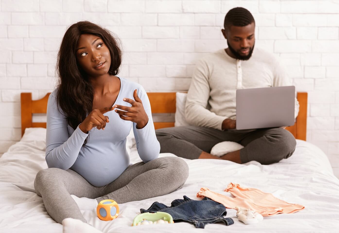 couple-sitting-on-bed-planning-for-their-baby