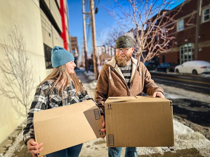 Two people moving boxes