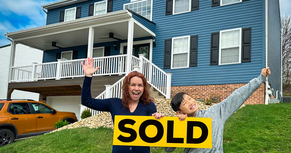 mom and son holding sold sign