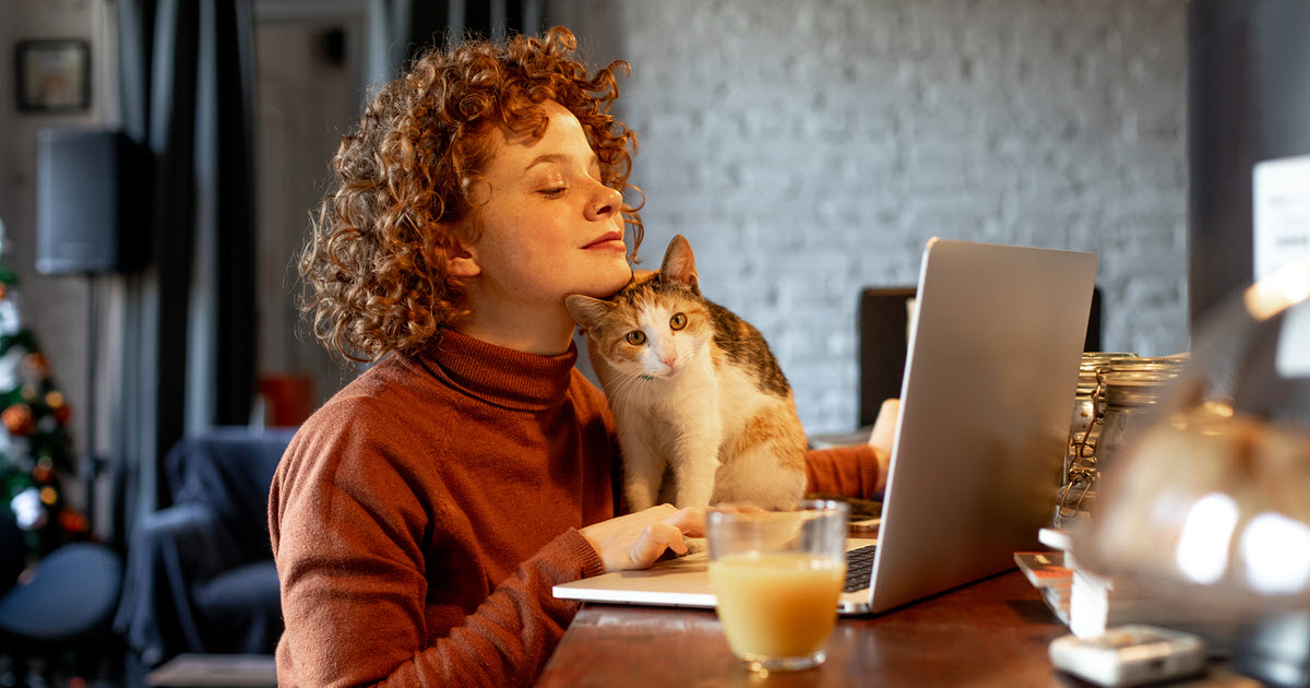 woman with cat using laptop