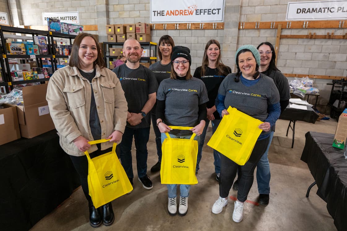 Employees holding Clearview tote bags