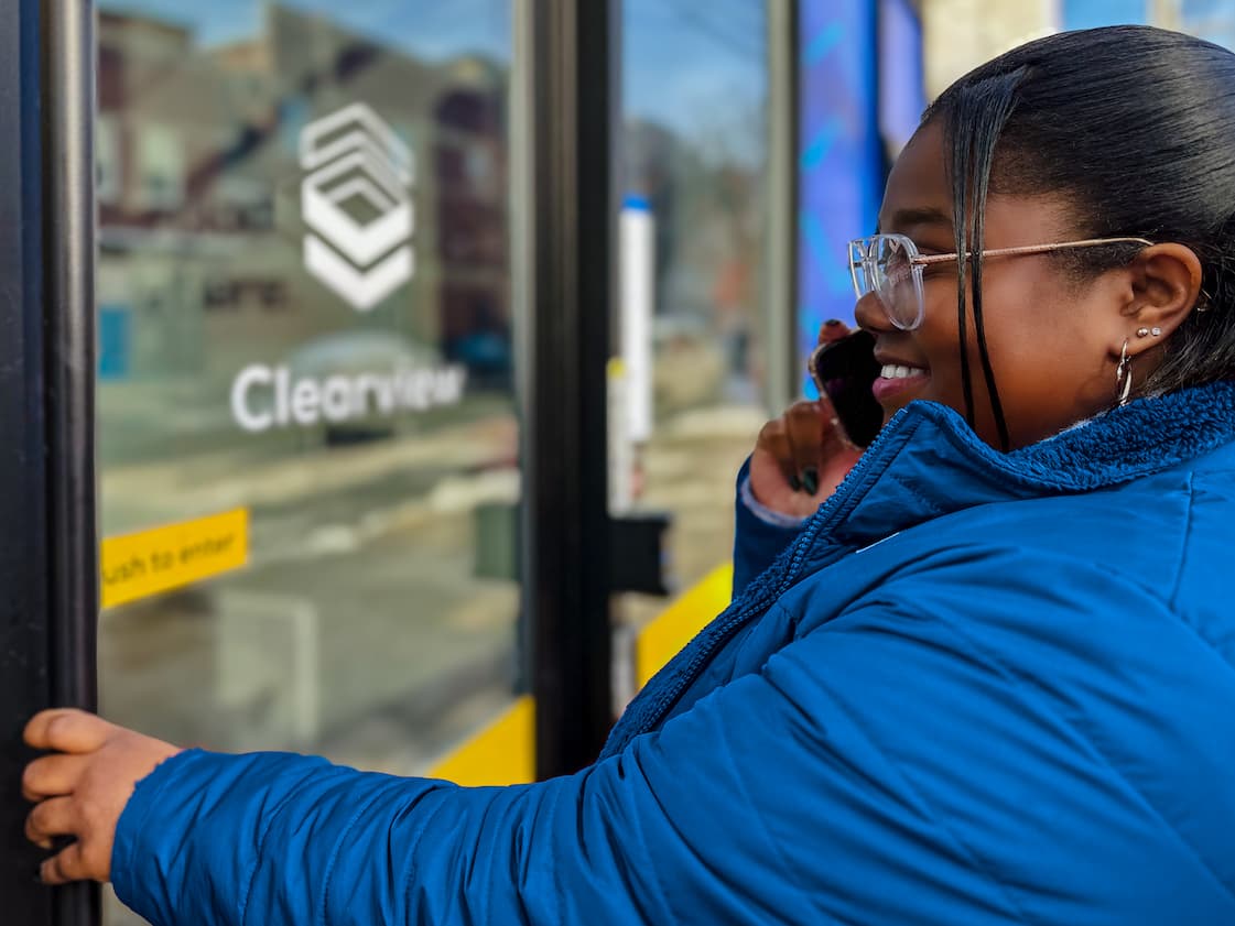 Person talking on phone while entering the credit union.
